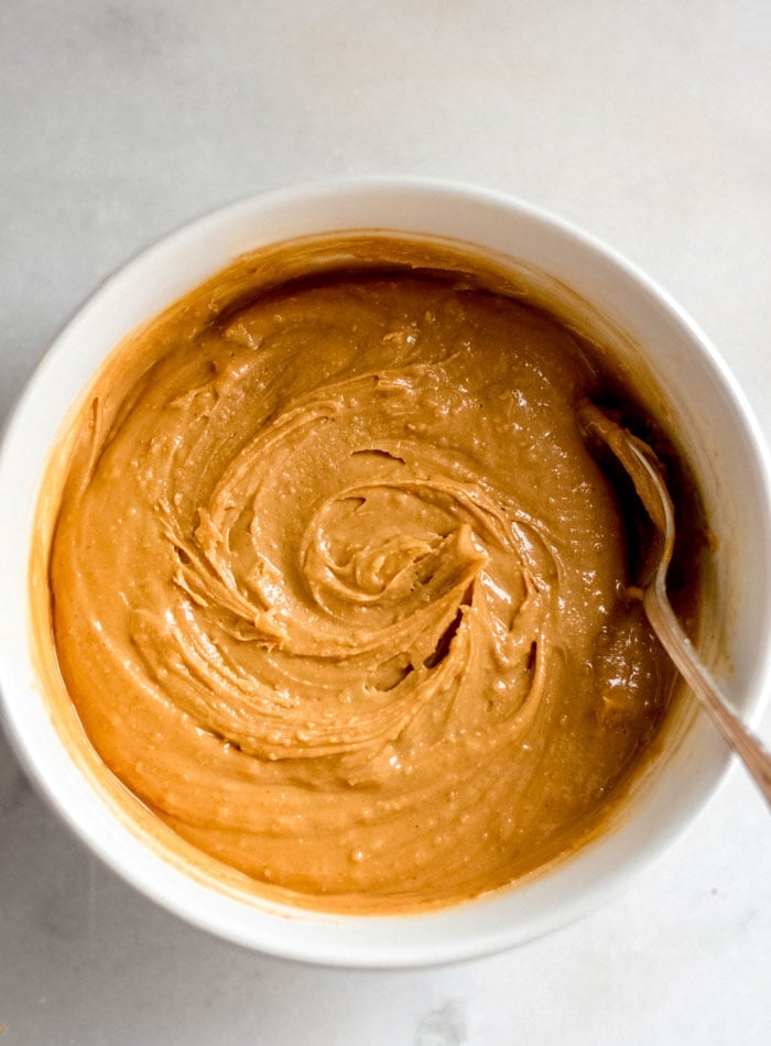 Peanut butter in a mixing bowl with a sppoon.