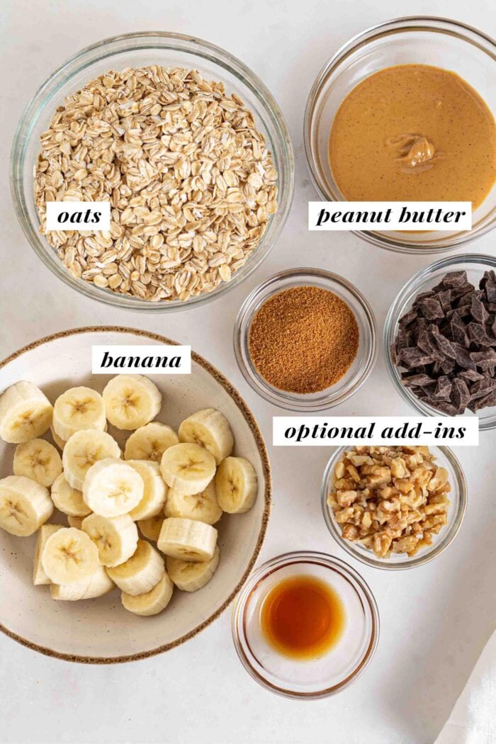 Bowls of oats, banana, peanut butter, chocolate chips, vanilla, coconut sugar and walnuts.