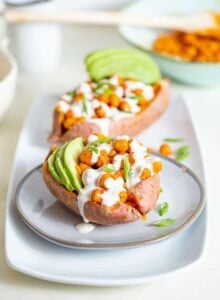 Sweet potato stuffed with buffalo chickpeas and avoado, topped with white sauce..
