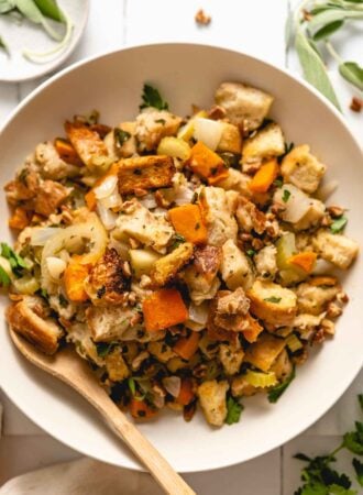 A bowl of butternut squash stuffing with bread, celery, apple and herbs.