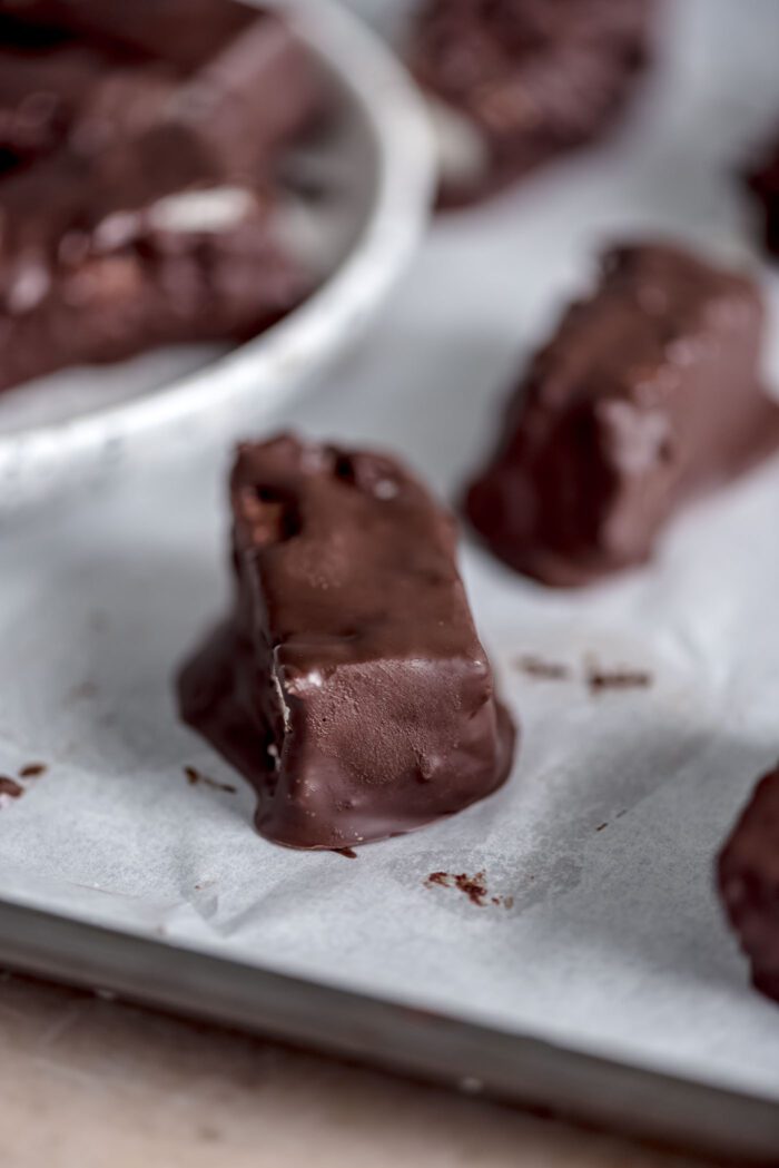 A mini homemade chocolate coated Mounds bar on a baking sheet lined with parchment paper.