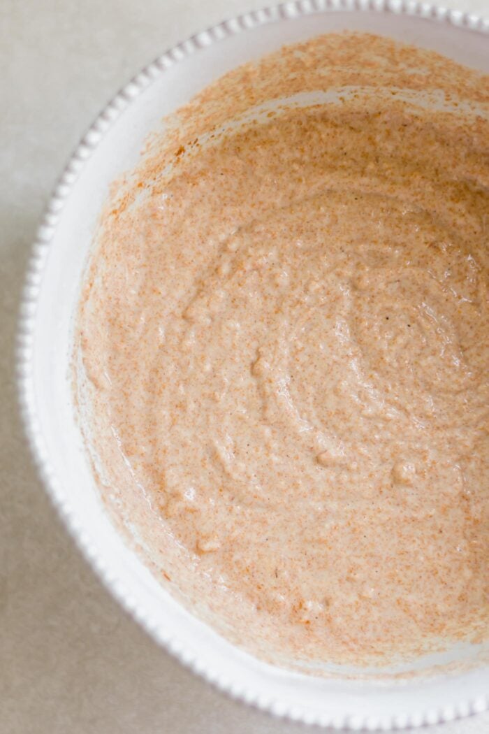 Overhead view into a medium mixing bowl of thick whole wheat pancake batter.