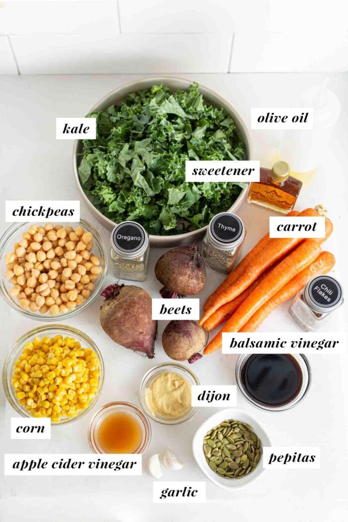 Various labelled ingredients in bowls and containers for a kale and beet salad.