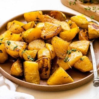 Plate of roasted golden beets with fresh thyme.