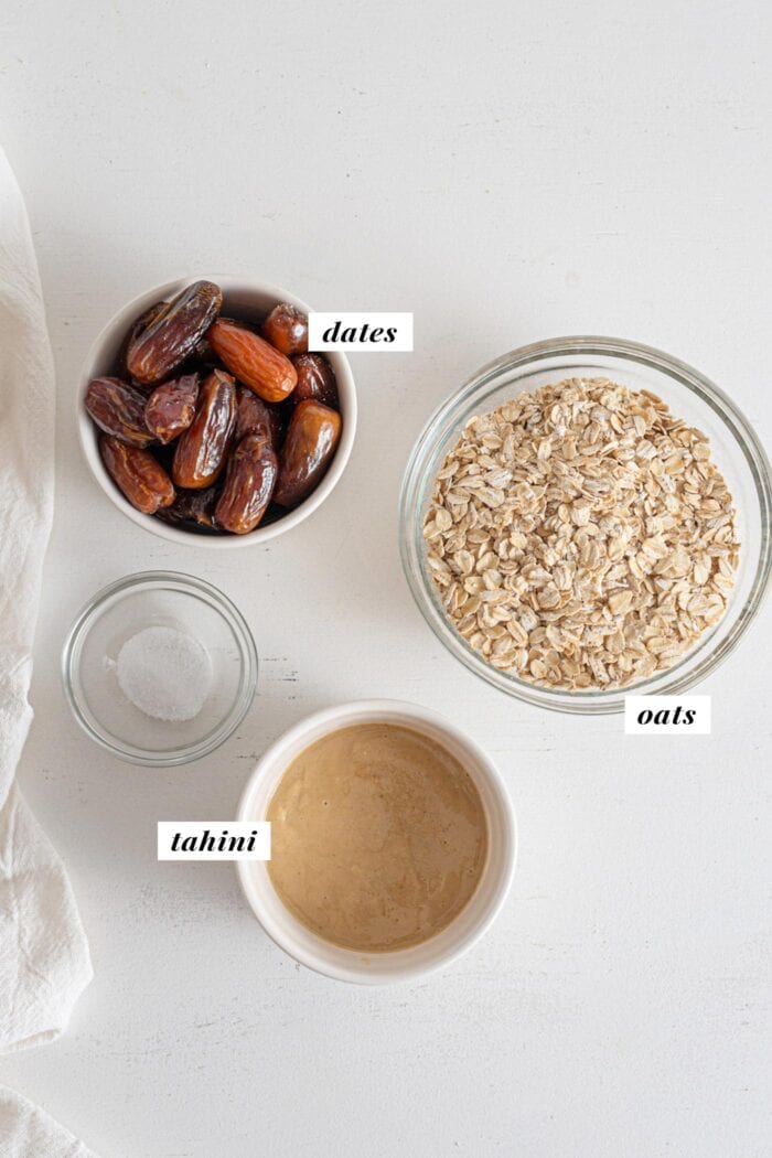 Oats, dates and tahini in bowls. Text overlay labels each ingredient.