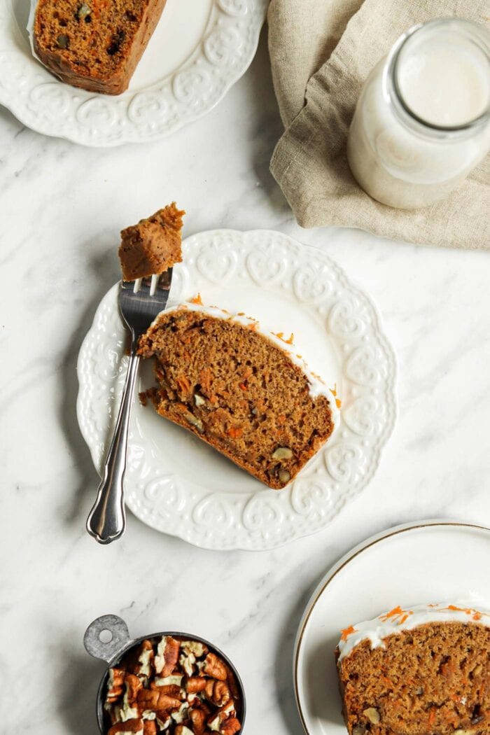 Slice of carrot banana bread on a small plate with a fork.