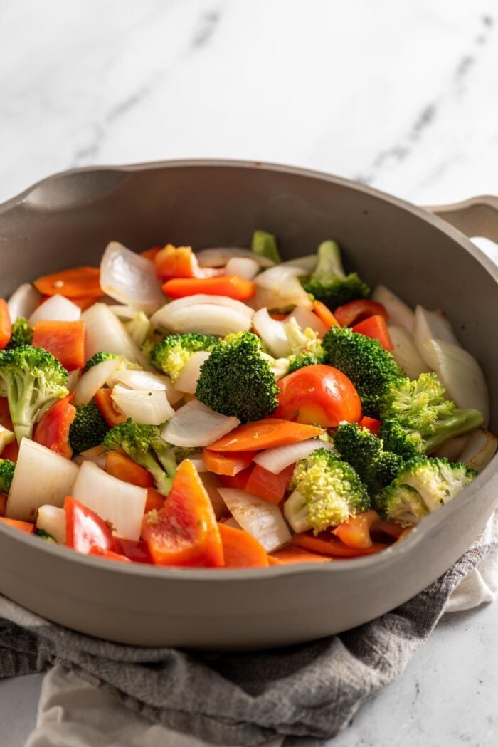 Stir fried chopped vegetables cooking in a skillet.