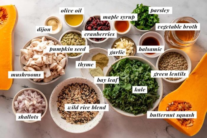 All of the ingredients needed for making a rice and lentil stuffed butternut squash recipe. Each ingredient is labelled with text.
