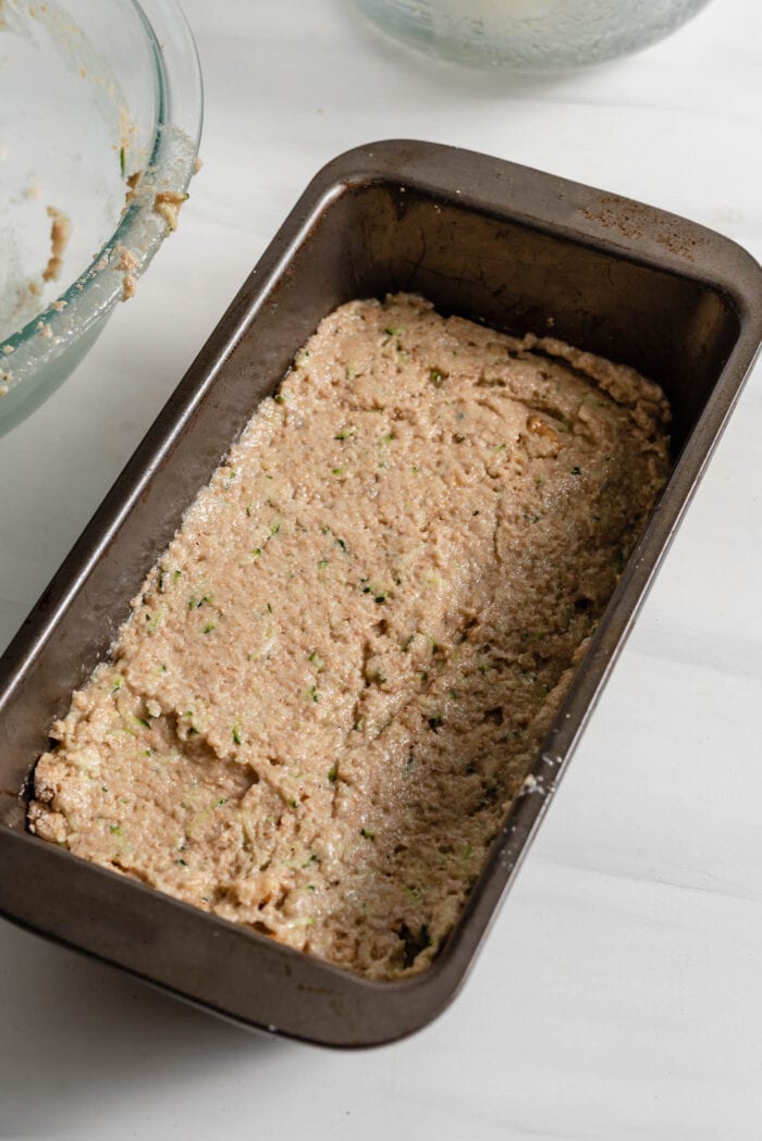 Raw zucchini bread batter in a loaf pan.